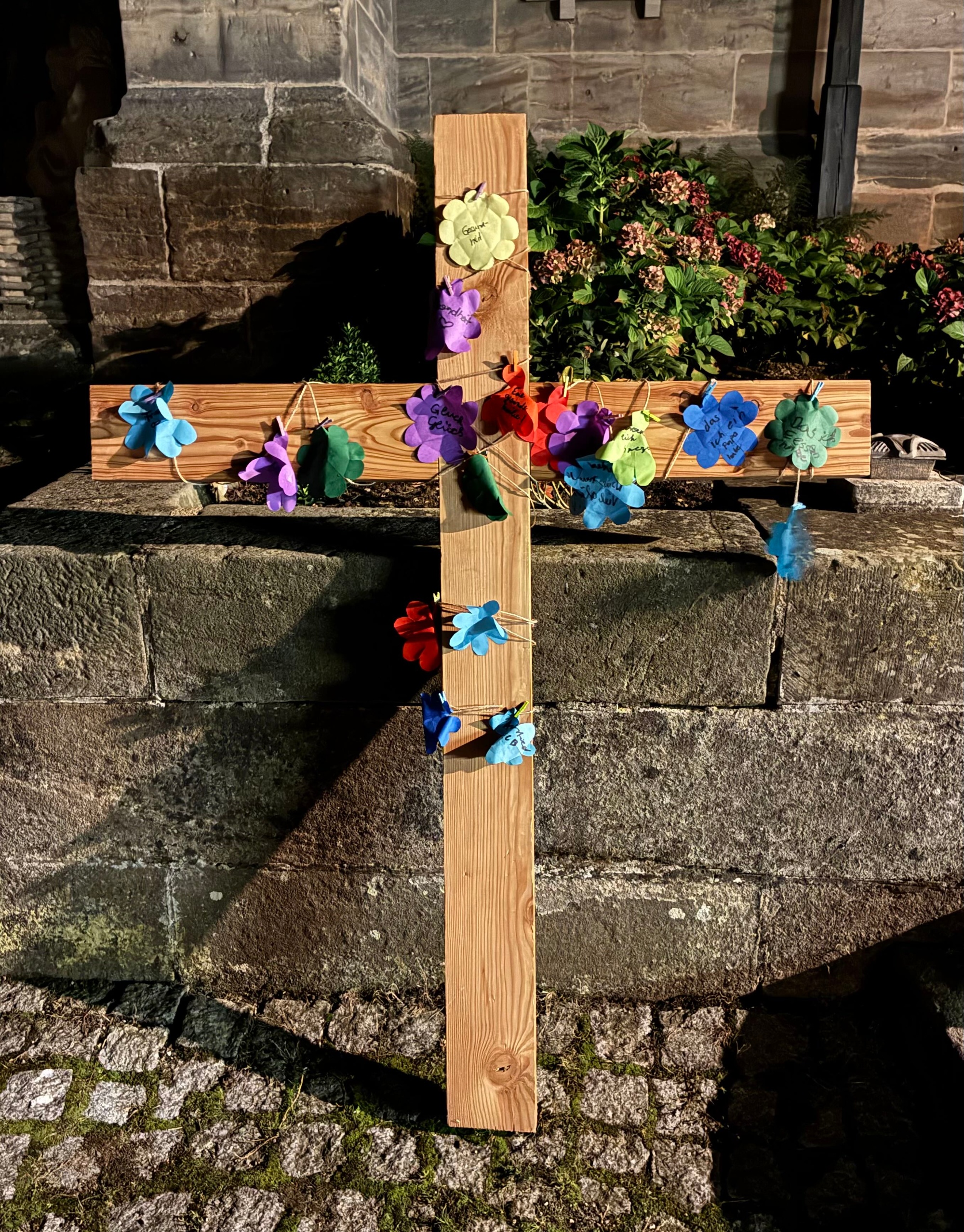 Nachtwanderung für Familien 2026 Zu sehen ist das Holzkreuz, an dem die aufgeblühten Papierblumen befestigt wurden.